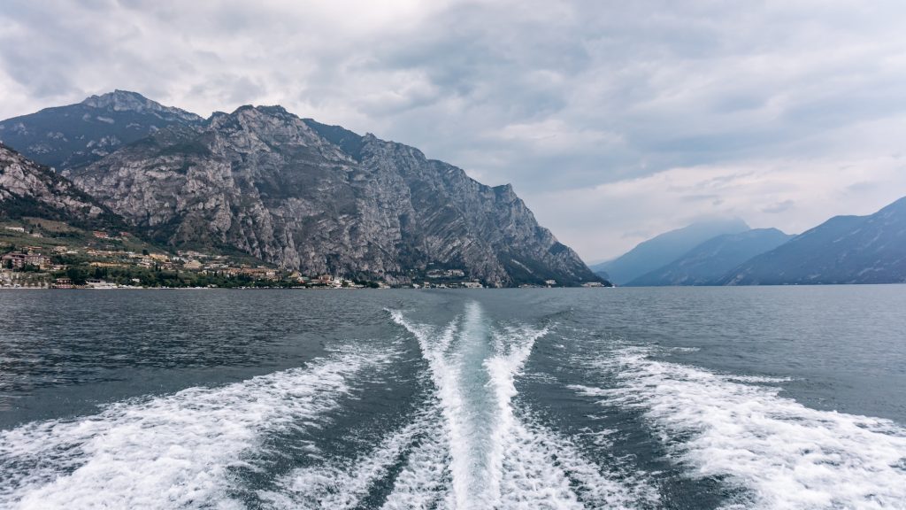 The trail of the boat on the sea. Sea with mountains in the background