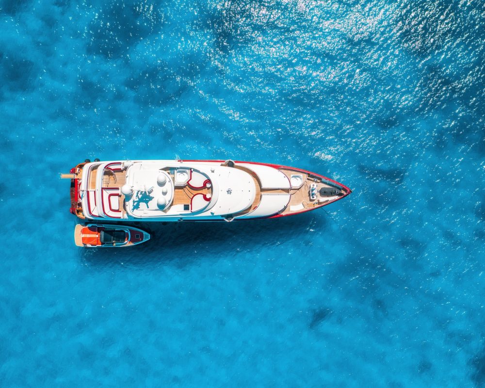 Aerial view of beautiful luxury yacht and boat in blue sea Aerial view of beautiful luxury yacht and boat in blue sea